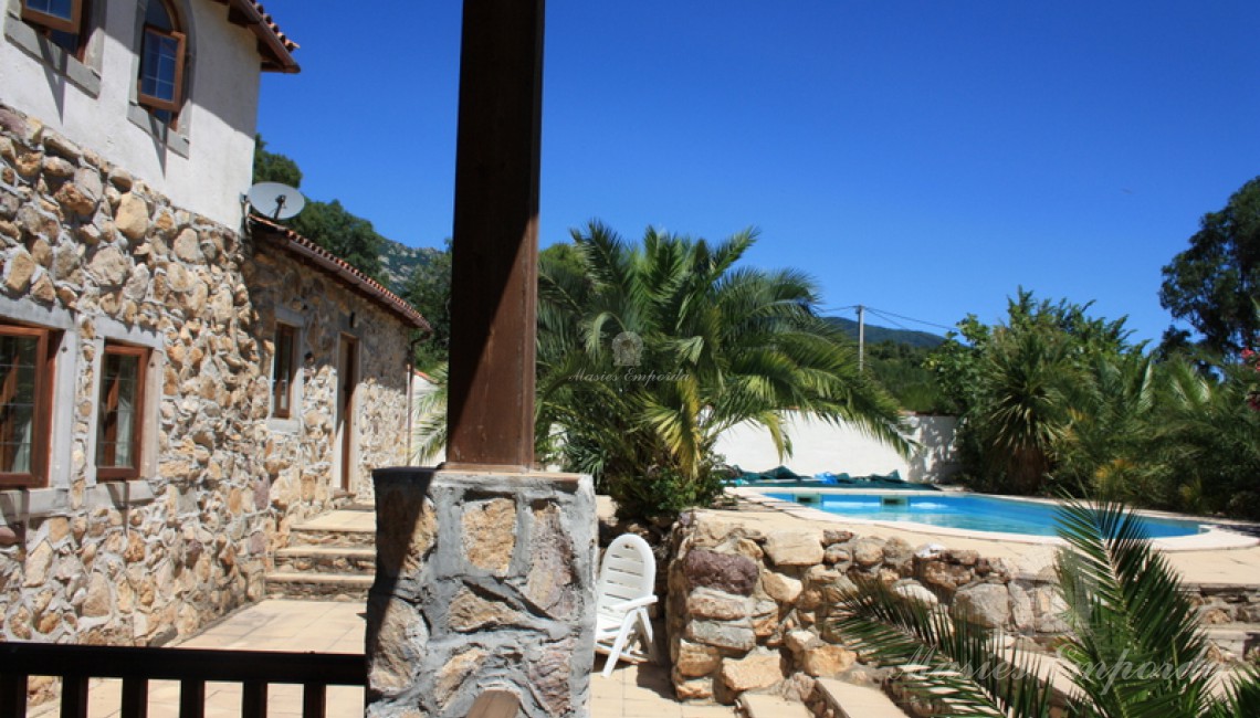 Vista de la piscina desde la terraza cubierta de la casa con vistas al valle