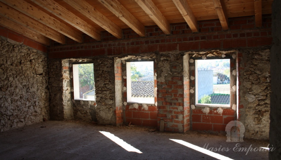 Ventanales al jardín de habitaciones de la tercera planta y detalle de cubierta con vigas de madera.