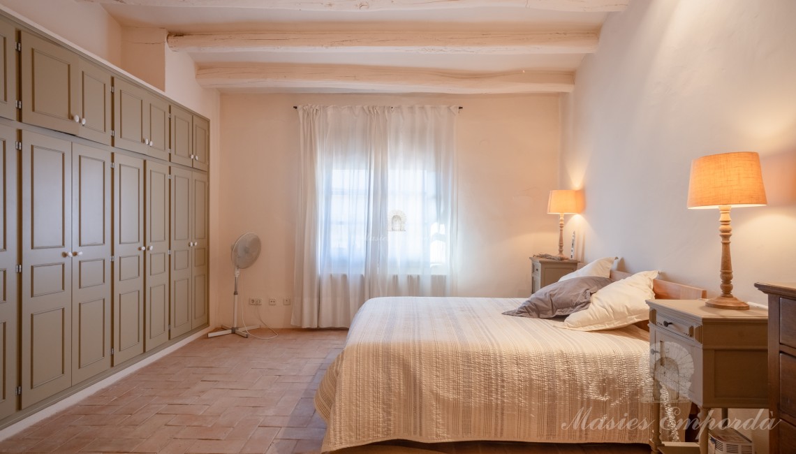 Habitación con acceso a terraza detalle de la vigas de madera vista en la cubierta. 