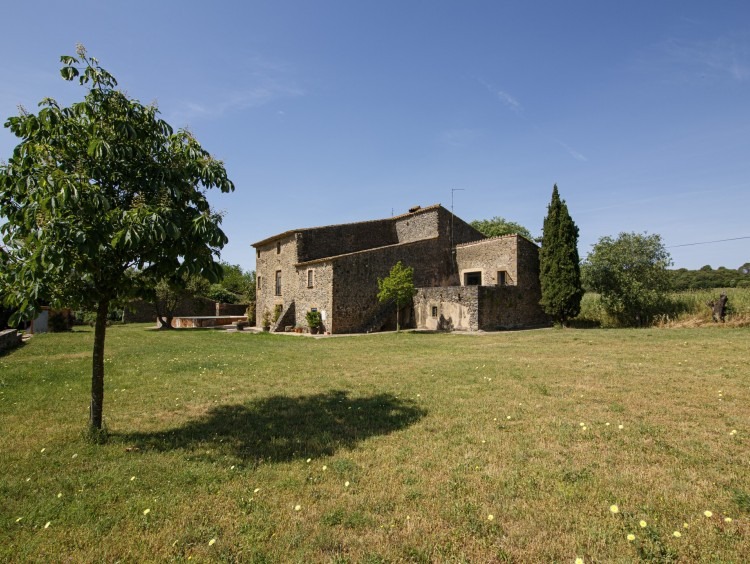 Vista general de la masía y el jardín