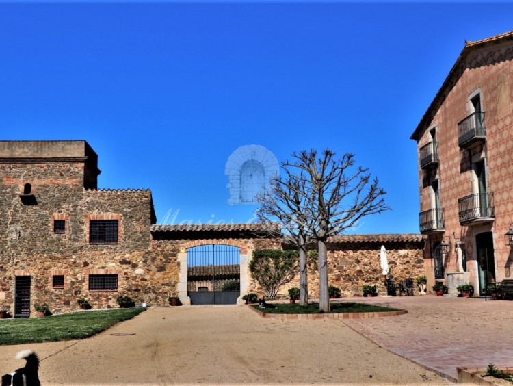 Vistas de la facha y la entrada al patio grande de la masía 